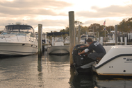 Man maintaining outboard motor at marina